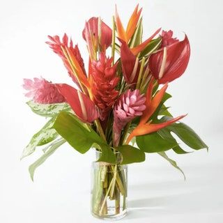Strauß rosa und orangefarbener Blumen in einer Glasvase