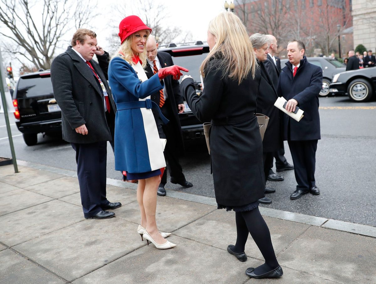Bilden kan innehålla Kläder Kläder Sko Skor Människoperson Reince Priebus Överrock Rock Kostym Hjul och maskin