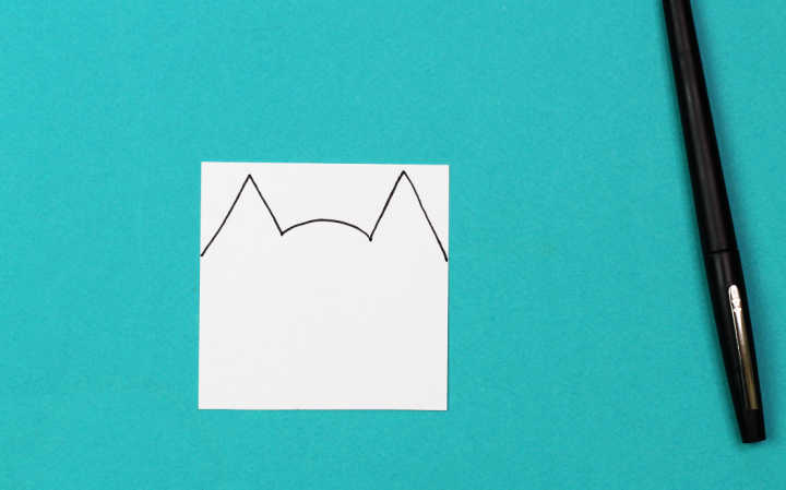   Katzenohren skizzieren auf quadratischem Papier mit Stift