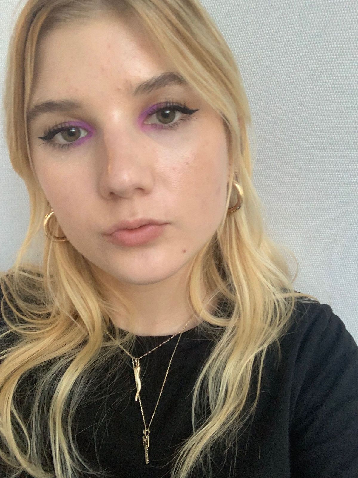 Bella Cacciatore con maquillaje morado neón