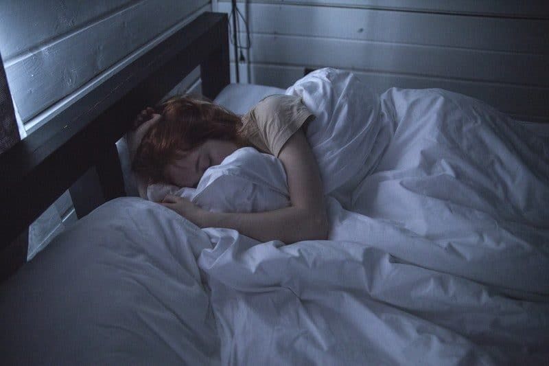 mujer durmiendo en una habitación azul oscuro