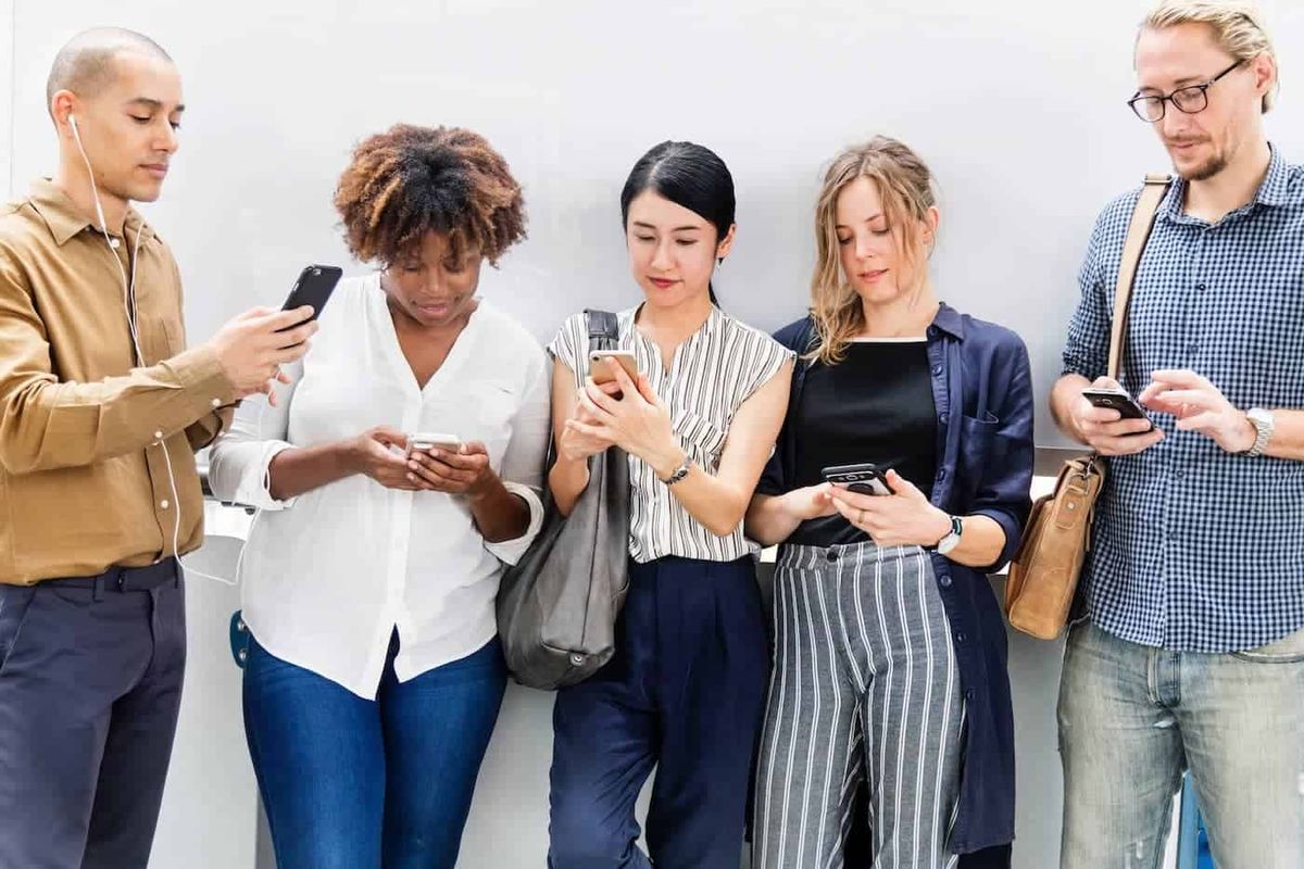 Grupp människor som använder sina mobiltelefoner