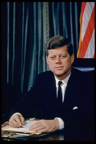 La imagen puede contener John F. Kennedy Persona humana Multitud Traje Abrigo Ropa Abrigo Ropa Bandera y símbolo