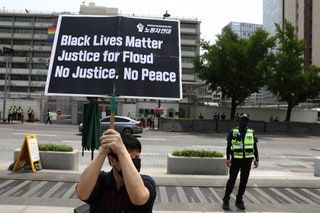 Un activista surcoreano sostiene una pancarta durante un mitin para llorar la muerte de George Floyd