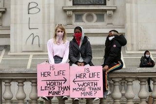 Los manifestantes en Londres Inglaterra se sientan con carteles que dicen que su vida vale más que la mía y su vida vale menos que la mía