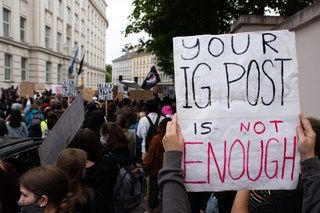 Un manifestante sostiene un cartel que dice