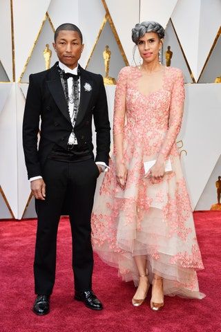La imagen puede contener Pharrell Williams Estreno de moda Alfombra roja Estreno de alfombra roja Persona humana Abrigo y traje