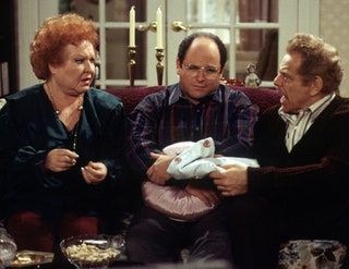 La imagen puede contener el sofá de muebles de persona humana y Jason Alexander