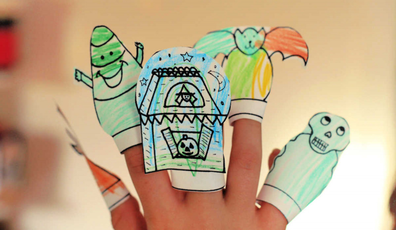   Niño's hand wearing five homemade Halloween finger puppets.