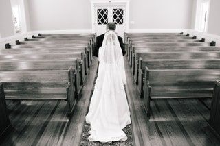 この画像には、屋内の衣料品アパレル、人間のファッション、ローブの通路のガウン、結婚式が含まれている場合があります