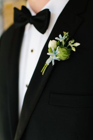 画像にはスーツコート服オーバーコートアパレル植物人間タキシードフラワーアレンジメントとフラワーが含まれている場合があります
