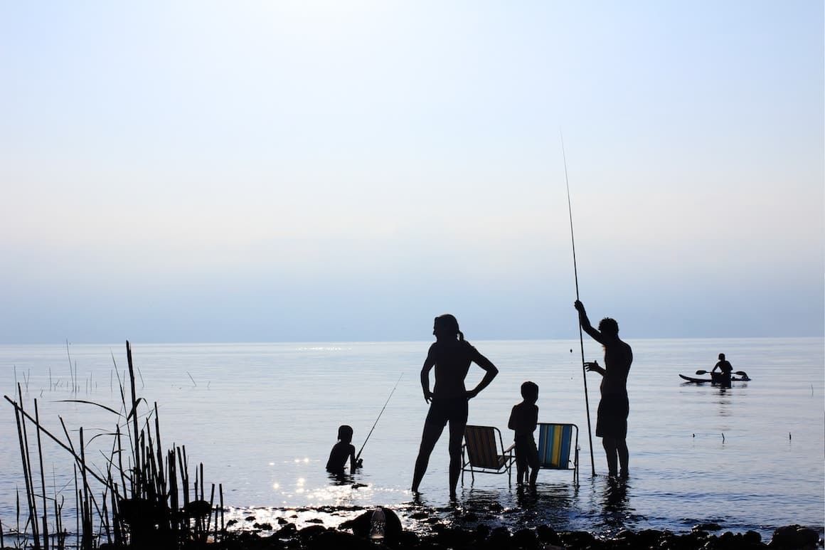 Familia pescando juntos en el lago.