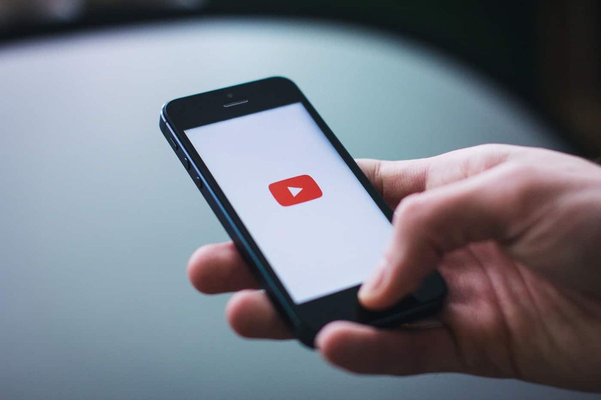Persona que abre la aplicación de Youtube en su teléfono inteligente