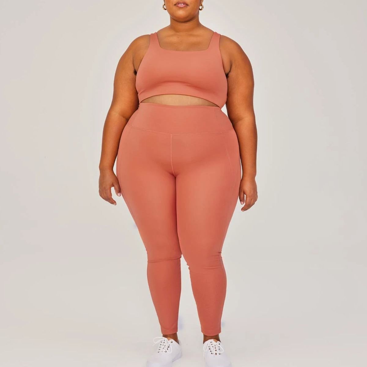 Model mit pfirsichfarbenen Leggings und passendem Sport-BH