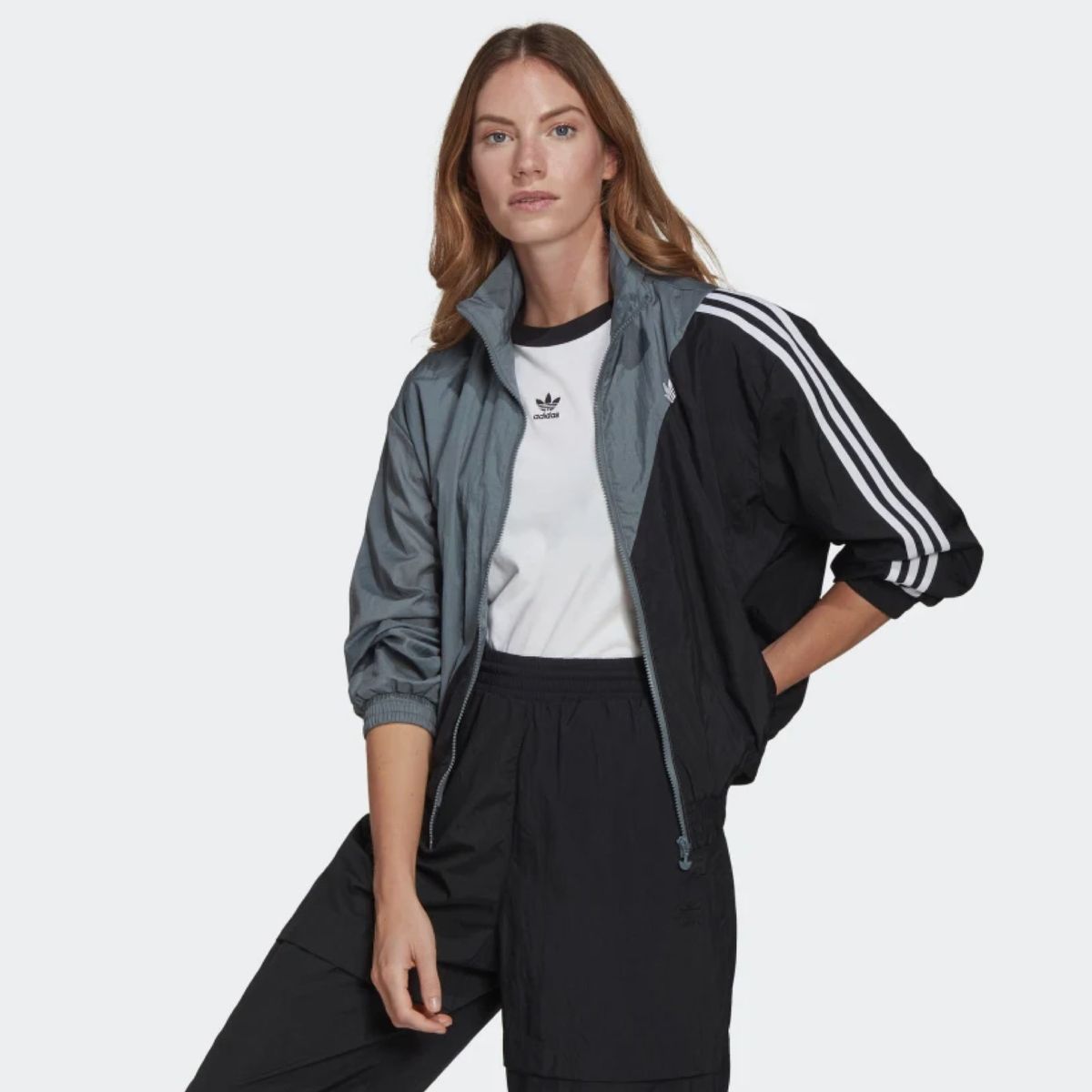 Model trägt schwarze Jacke mit weißen Armstreifen