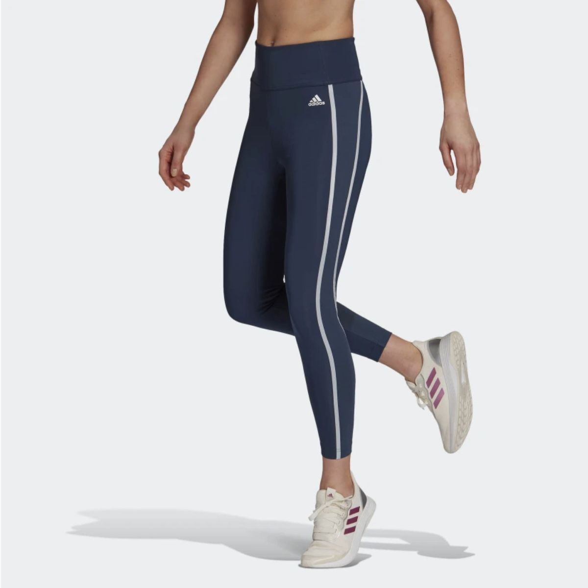 Model trägt blaue Leggings mit weißen Seitenstreifen
