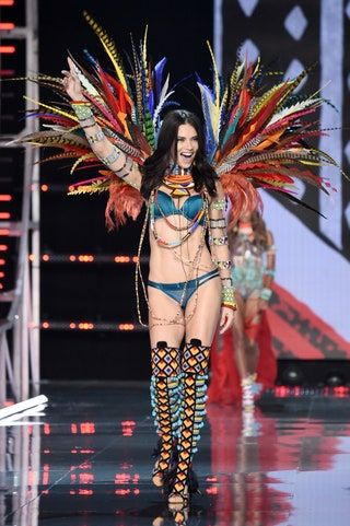 La imagen puede contener Disfraz y piel de Adriana Lima Human Crowd Person Stage Festival
