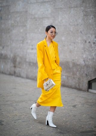 画像には、衣料品のコート、人間のレインコート、靴、靴が含まれている場合があります