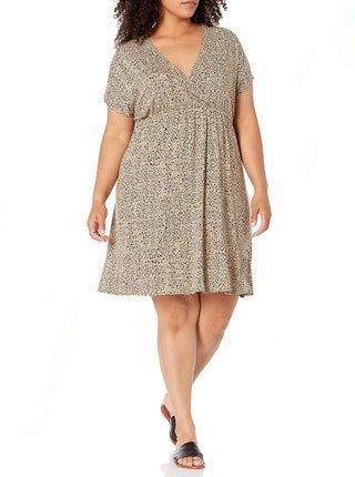 Model trägt ein Wickelkleid mit beigem und schwarzem Polka Dots