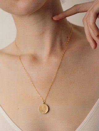La imagen puede contener collar, accesorios de joyería, accesorio, persona humana y colgante