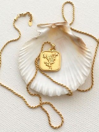 La imagen puede contener colgante, collar, accesorios de joyería, accesorio y oro