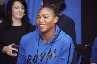 Serena Williams lächelt in einem blauen Sweatshirt.