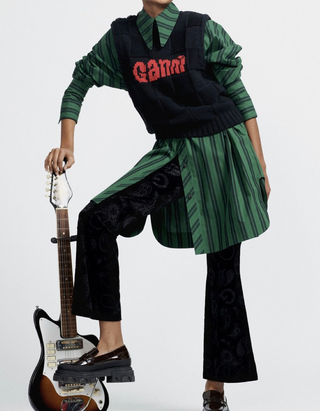 Model mit Gitarre im grün-schwarz gestreiften Hemdkleid