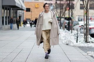 Das Bild kann enthalten Kleidung Bekleidung Mantel Menschliche Person Mantel Schuhe Schuh Fahrzeug Transport und Auto