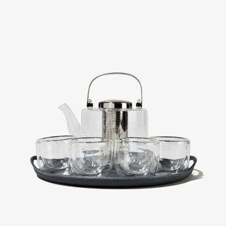 Teeservice aus Glas mit Wasserkocher und Tassen auf einem Tablett