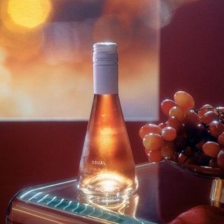 Flasche Rose neben einer Weintraube