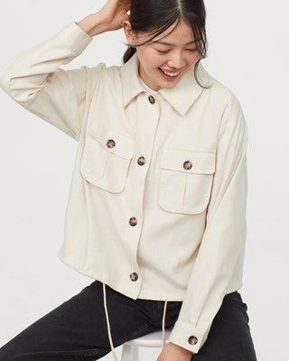 La imagen puede contener ropa, ropa, camisa, persona humana, color caqui y manga