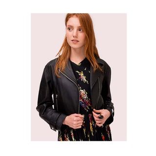 modelo de pelo rojo con vestido negro estampado y chaqueta de cuero