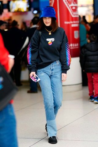 ベラハディッドは空港にジーンズとバケツの帽子をかぶっています