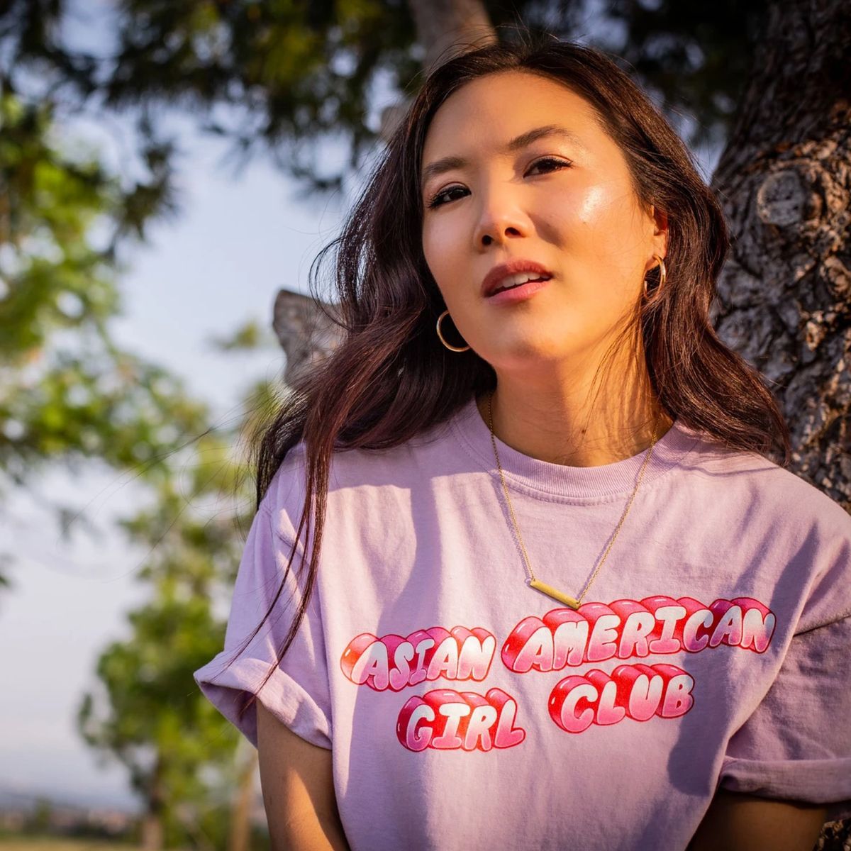 modelo vistiendo camiseta morada con escritura de burbuja rosa