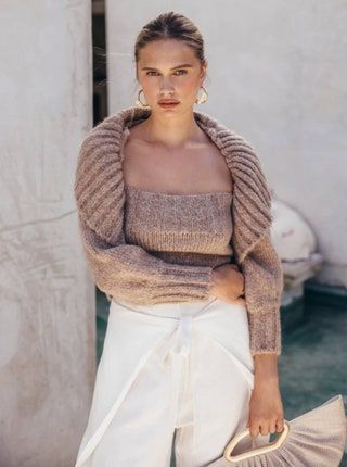 modell klädd i tjocka beige tröjaärmar och matchande topp