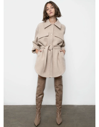modelo vistiendo chaqueta beige con cinturón