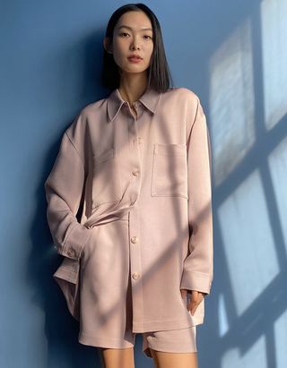 modelo con chaqueta rosa claro con pantalones cortos a juego