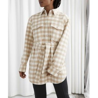 modelo vistiendo chaqueta a cuadros beige y blanco con cinturón