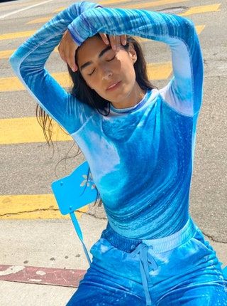 Modelo vistiendo una camisa de manga larga de felpa azul y blanca con pantalones a juego