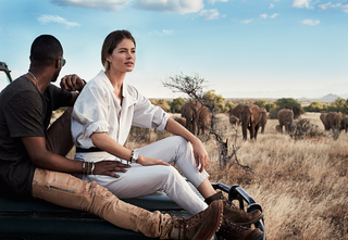 ربما تحتوي الصورة على Doutzen Kroes Clothing ملابس شخص بشري الحياة البرية الحيوانية الثدييات الفيل الأحذية والجلوس