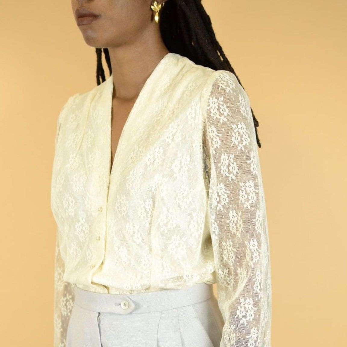 modelo con blusa transparente de encaje marfil