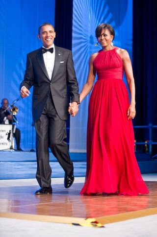Bilden kan innehålla Michelle Obama Barack Obama Kostym Kappa Kläder Överrock Kläder Människoperson och mode