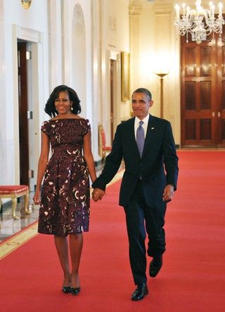 Bilden kan innehålla Michelle Obama Slips Accessoarer Accessoar Mode Människoperson Kostym Kappa Kläder och överrock