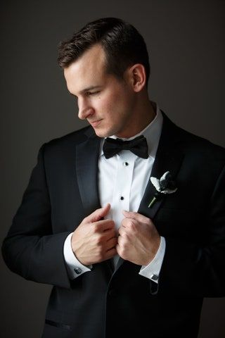 Bilden kan innehålla Tillbehör Slips Tillbehör Kläder Kläder Kostym Överrock Kappa Smoking Människo och person
